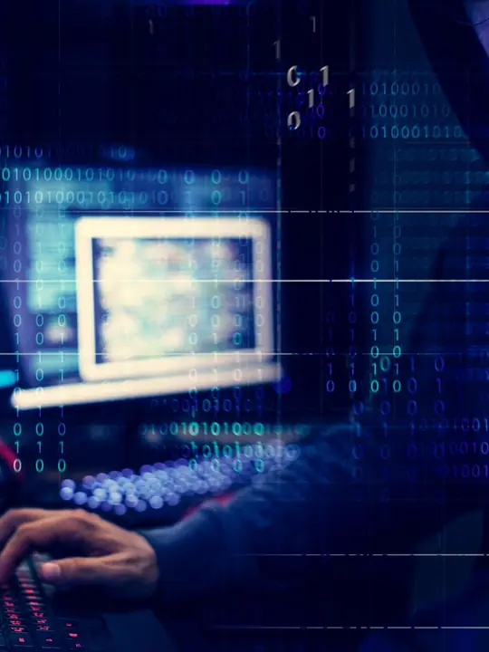 Persona al computer davanti a un flusso di codice binario